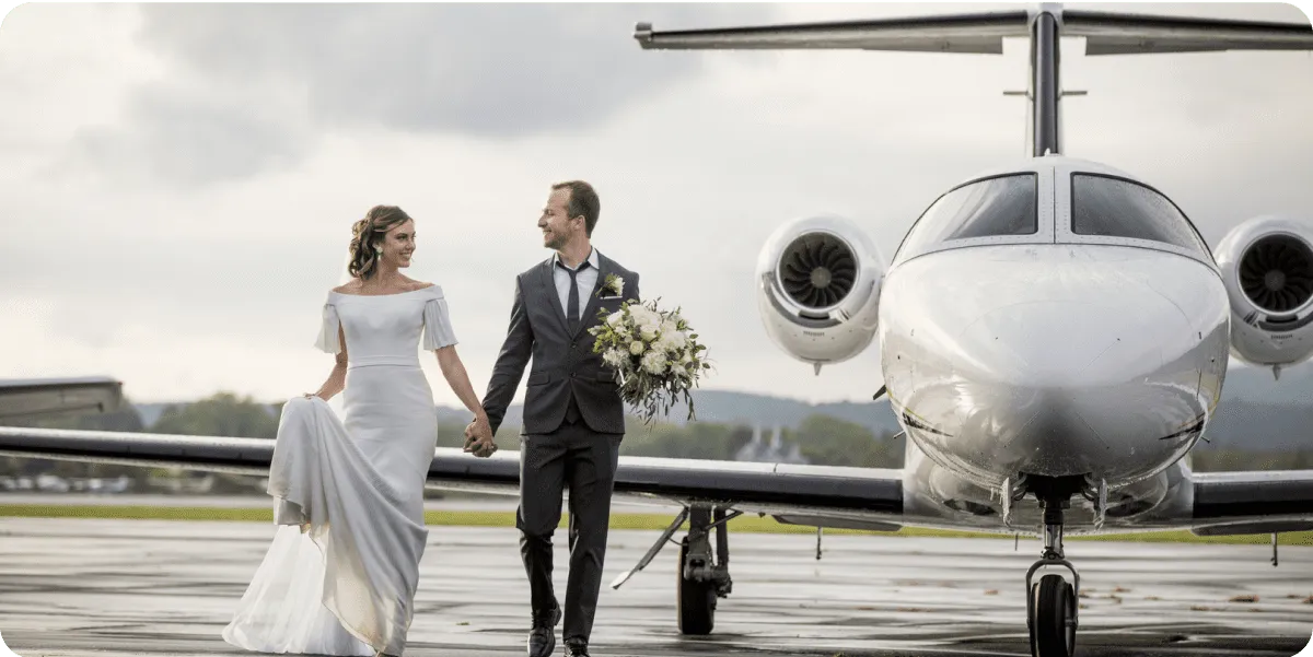 Wedding couple walking beside a private jet